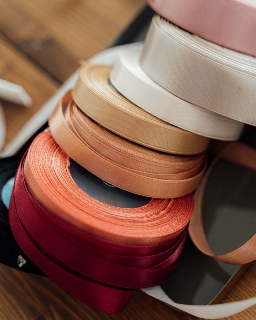 Spools of satin ribbon in blush, cream and coral