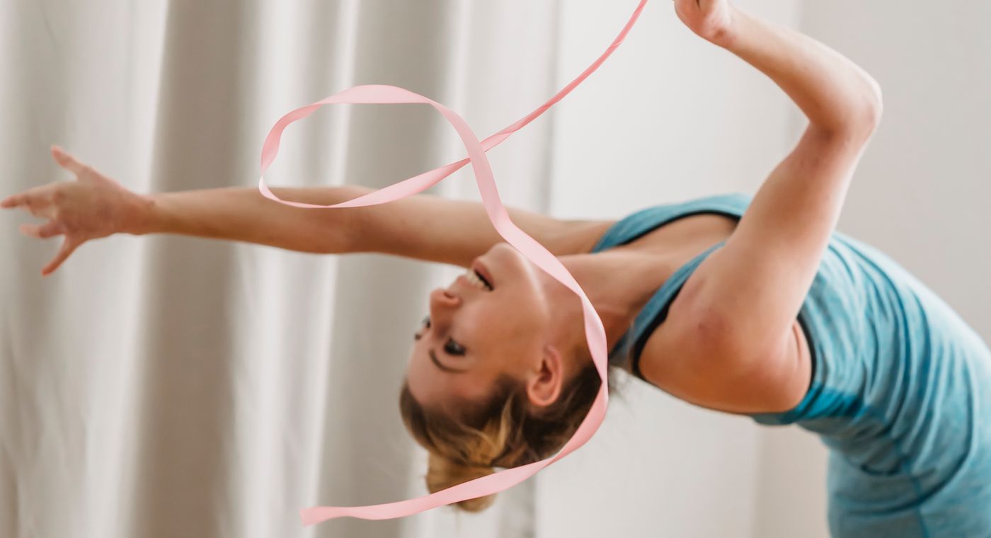 A rhythmic gymnast arching with a ribbon